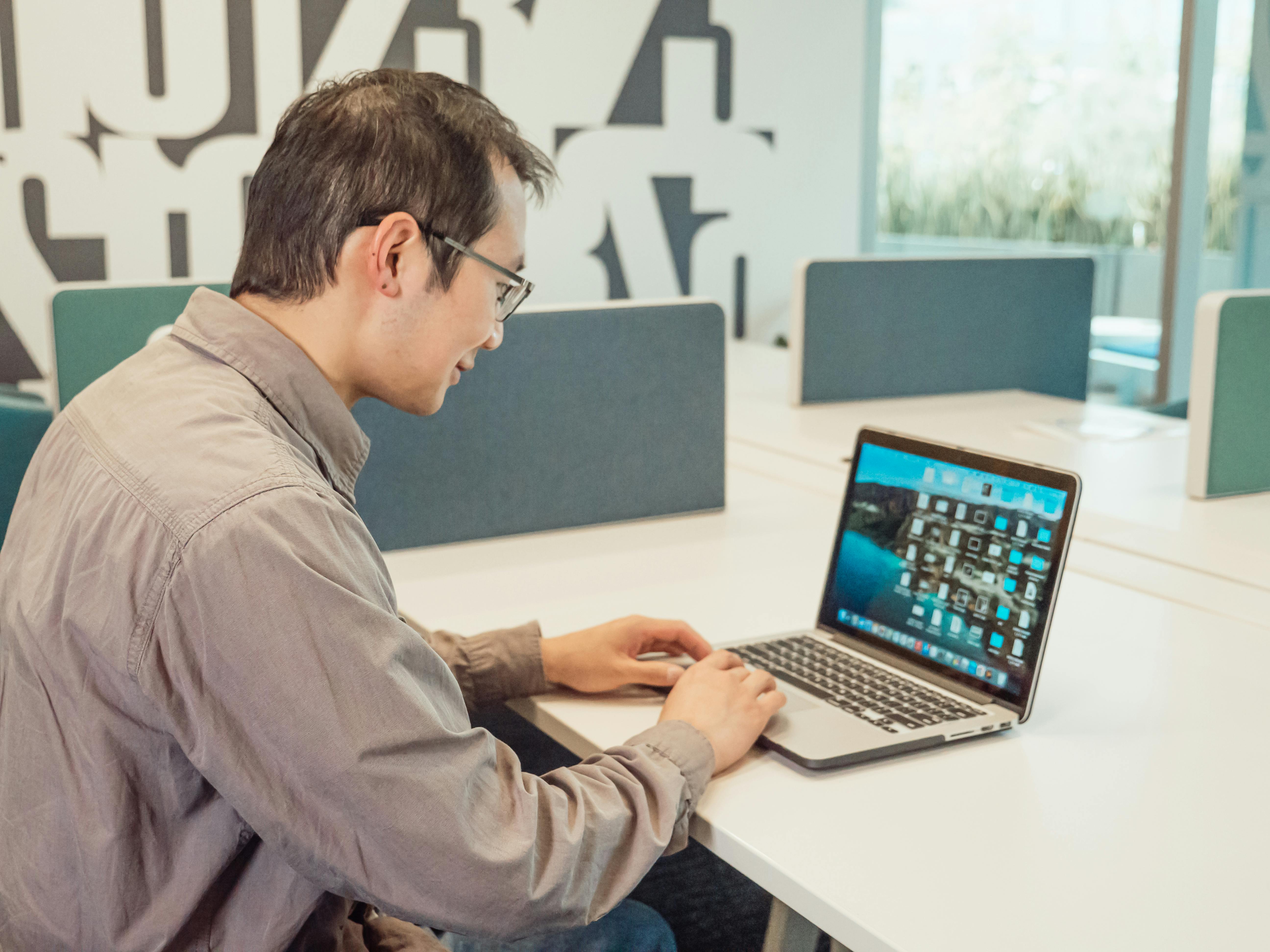 Asian IT professional working on a laptop in a modern office